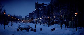 Movie still from “The Sum of All Fears” (2002), directed by Phil Alden Robinson – A city street with snow on the ground and lights on; Extreme Wide shot, High angle