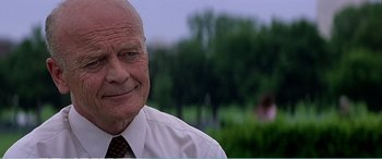 Movie still from “The Sum of All Fears” (2002), directed by Phil Alden Robinson – An older man wearing a white dress shirt and tie; Close Up shot, Over the shoulder angle