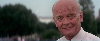 Movie still from “The Sum of All Fears” (2002), directed by Phil Alden Robinson – An older man wearing a white shirt and a tie; Close Up shot, Over the shoulder angle