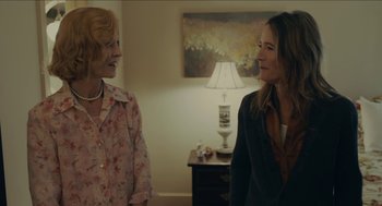 Movie still from “The Taking of Deborah Logan” (2014), directed by Adam Robitel – Two women standing next to each other in front of a lamp; Medium shot, Over the shoulder angle