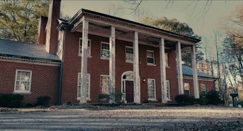 Movie still from “The Taking of Deborah Logan” (2014), directed by Adam Robitel – An old red brick building with columns and a porch; Extreme Wide shot, Low angle