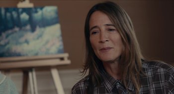 Movie still from “The Taking of Deborah Logan” (2014), directed by Adam Robitel – A person sitting in a room near a painting; Close Up shot, Over the shoulder angle