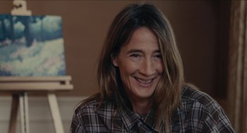 Movie still from “The Taking of Deborah Logan” (2014), directed by Adam Robitel – A woman with long brown hair smiling for the camera; Close Up shot, Over the shoulder angle