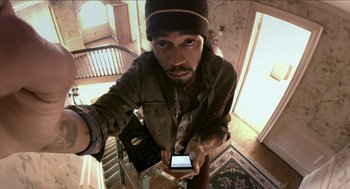 Movie still from “The Taking of Deborah Logan” (2014), directed by Adam Robitel – A man holding a cell phone in his hand; Medium shot, Overhead angle