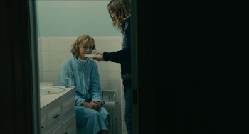 Movie still from “The Taking of Deborah Logan” (2014), directed by Adam Robitel – A woman in a blue bathrobe in a bathroom with another woman; Medium shot, Over the shoulder angle