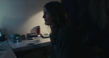 Movie still from “The Taking of Deborah Logan” (2014), directed by Adam Robitel – A woman sitting in front of a table with a cell phone on top of it; Medium shot, High angle