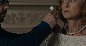 Movie still from “The Taking of Deborah Logan” (2014), directed by Adam Robitel – A person is holding a pair of headphones in their ear; Close Up shot, Over the shoulder angle