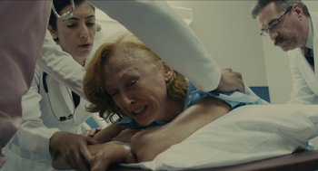 Movie still from “The Taking of Deborah Logan” (2014), directed by Adam Robitel – An older woman laying in a hospital bed; Medium shot, High angle