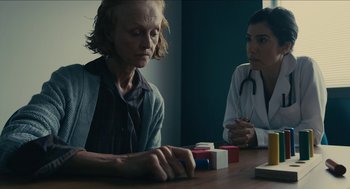 Movie still from “The Taking of Deborah Logan” (2014), directed by Adam Robitel – A woman sitting at a table with another woman; Medium shot, Over the shoulder angle