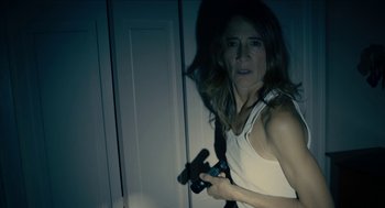 Movie still from “The Taking of Deborah Logan” (2014), directed by Adam Robitel – A woman holding a remote control in her hand; Medium shot, High angle