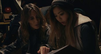 Movie still from “The Taking of Deborah Logan” (2014), directed by Adam Robitel – A woman and a girl looking at something on a book; Close Up shot, High angle