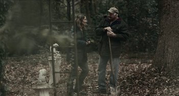 Movie still from “The Taking of Deborah Logan” (2014), directed by Adam Robitel – A man and a woman standing next to each other in the woods; Wide shot, Over the shoulder angle