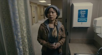 Movie still from “The Taking of Deborah Logan” (2014), directed by Adam Robitel – A woman holding a coffee cup in a room; Medium shot, Over the shoulder angle