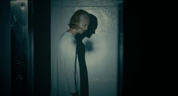 Movie still from “The Taking of Deborah Logan” (2014), directed by Adam Robitel – A woman standing next to a man in a dark room; Medium shot, Low angle