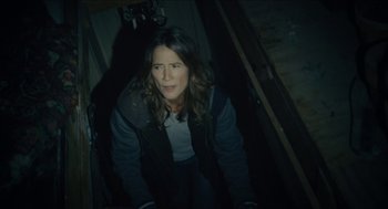 Movie still from “The Taking of Deborah Logan” (2014), directed by Adam Robitel – A woman is sitting in a dark room; Medium shot, High angle