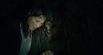 Movie still from “The Taking of Deborah Logan” (2014), directed by Adam Robitel – A woman with curly hair is looking down at her hands; Close Up shot, High angle