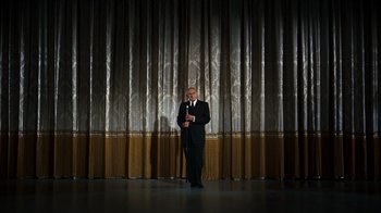 Movie still from “The Ten Commandments” (1956), directed by Cecil B. DeMille – A man standing in front of a curtain on a stage; Wide shot, Low angle