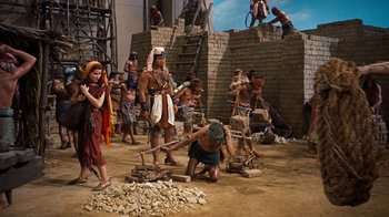 Movie still from “The Ten Commandments” (1956), directed by Cecil B. DeMille – A group of people standing next to each other on a dirt field; Wide shot, High angle