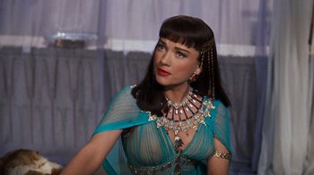 Movie still from “The Ten Commandments” (1956), directed by Cecil B. DeMille – A woman wearing a blue dress and a necklace; Close Up shot, Over the shoulder angle