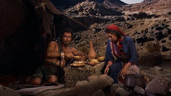 Movie still from “The Ten Commandments” (1956), directed by Cecil B. DeMille – A man and a woman sitting on a bench; Medium shot, High angle