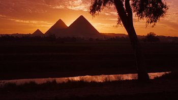 Movie still from “The Ten Commandments” (1956), directed by Cecil B. DeMille – The sun sets over a field with three pyramids in the background; Extreme Wide shot, Low angle