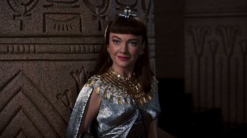 Movie still from “The Ten Commandments” (1956), directed by Cecil B. DeMille – A woman dressed as cleopatra standing in front of a wall; Close Up shot, Over the shoulder angle