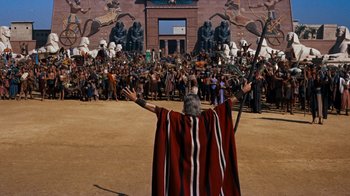 Movie still from “The Ten Commandments” (1956), directed by Cecil B. DeMille – An old man in a red and black cape holding a spear; Extreme Wide shot, High angle