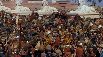 Movie still from “The Ten Commandments” (1956), directed by Cecil B. DeMille – A crowd of people sitting on top of a pile of rocks; Extreme Wide shot, High angle