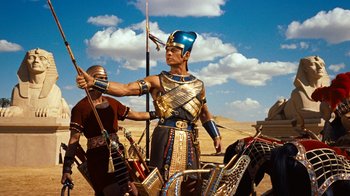 Movie still from “The Ten Commandments” (1956), directed by Cecil B. DeMille – A man dressed as a pharaoh standing next to a horse; Medium shot, Low angle