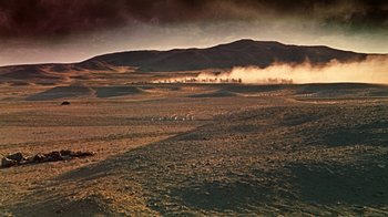 Movie still from “The Ten Commandments” (1956), directed by Cecil B. DeMille – A field with a mountain in the background and smoke billowing from it; Extreme Wide shot, High angle