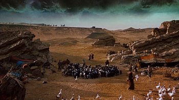 Movie still from “The Ten Commandments” (1956), directed by Cecil B. DeMille – A flock of birds standing on top of a sandy beach; Extreme Wide shot, High angle