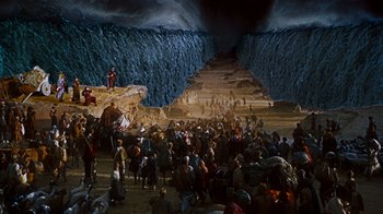 Movie still from “The Ten Commandments” (1956), directed by Cecil B. DeMille – A group of people standing in front of a cave; Extreme Wide shot, High angle