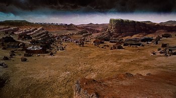 Movie still from “The Ten Commandments” (1956), directed by Cecil B. DeMille – A group of people walking across a dirt field; Extreme Wide shot, High angle