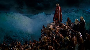 Movie still from “The Ten Commandments” (1956), directed by Cecil B. DeMille – A crowd of people gathered around a man on top of a mountain; Extreme Wide shot, High angle