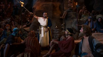 Movie still from “The Ten Commandments” (1956), directed by Cecil B. DeMille – A man holding a sword in front of a group of people; Wide shot, High angle
