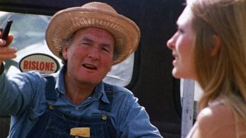 Movie still from “The Texas Chain Saw Massacre” (1974), directed by Tobe Hooper – An older man wearing a straw hat talking to a young woman; Close Up shot, Over the shoulder angle