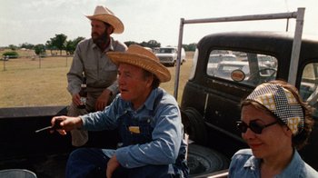 Movie still from “The Texas Chain Saw Massacre” (1974), directed by Tobe Hooper – A group of men sitting in the back of a truck; Medium shot, Over the shoulder angle