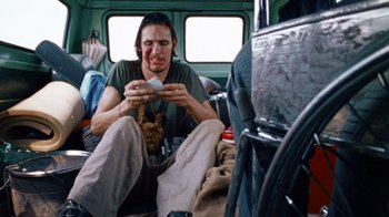 Movie still from “The Texas Chain Saw Massacre” (1974), directed by Tobe Hooper – A man sitting on the floor of a bus; Medium shot, Low angle
