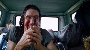 Movie still from “The Texas Chain Saw Massacre” (1974), directed by Tobe Hooper – A man holding a cell phone in his hand; Close Up shot, Low angle