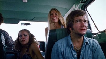 Movie still from “The Texas Chain Saw Massacre” (1974), directed by Tobe Hooper – A group of people riding in the back of a car; Medium shot, Low angle