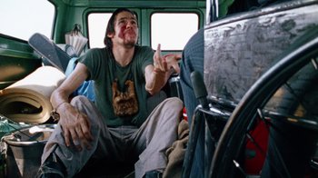 Movie still from “The Texas Chain Saw Massacre” (1974), directed by Tobe Hooper – A man sitting on the floor of a bus; Medium shot, Over the shoulder angle
