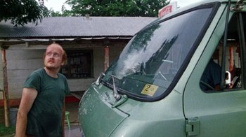 Movie still from “The Texas Chain Saw Massacre” (1974), directed by Tobe Hooper – A man standing in front of a green van; Medium shot, Over the shoulder angle
