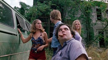 Movie still from “The Texas Chain Saw Massacre” (1974), directed by Tobe Hooper – A group of people standing next to each other in a field; Medium shot, Low angle