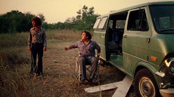 Movie still from “The Texas Chain Saw Massacre” (1974), directed by Tobe Hooper – A man sitting in a wheel chair next to a van; Wide shot, High angle