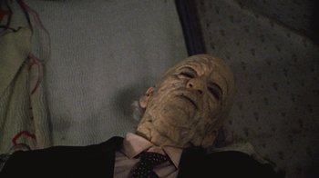 Movie still from “The Texas Chain Saw Massacre” (1974), directed by Tobe Hooper – An old man in a suit and tie looking up; Close Up shot, High angle