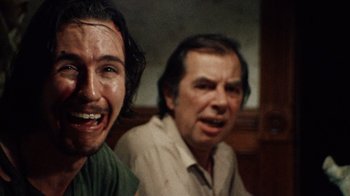 Movie still from “The Texas Chain Saw Massacre” (1974), directed by Tobe Hooper – A man and a man in a green shirt; Close Up shot, Over the shoulder angle