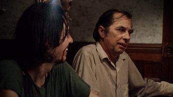 Movie still from “The Texas Chain Saw Massacre” (1974), directed by Tobe Hooper – A man and a woman sitting next to each other in a room; Close Up shot, Over the shoulder angle