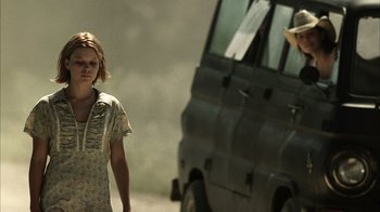 Movie still from “The Texas Chainsaw Massacre” (2003), directed by Marcus Nispel – A woman standing in front of a car on the side of the road; Medium shot, Low angle
