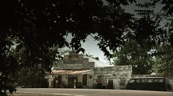 Movie still from “The Texas Chainsaw Massacre” (2003), directed by Marcus Nispel – An old building with a tree in front of it; Extreme Wide shot, Low angle