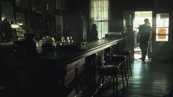 Movie still from “The Texas Chainsaw Massacre” (2003), directed by Marcus Nispel – A bar with a lot of stools in the middle of the room; Wide shot, Low angle